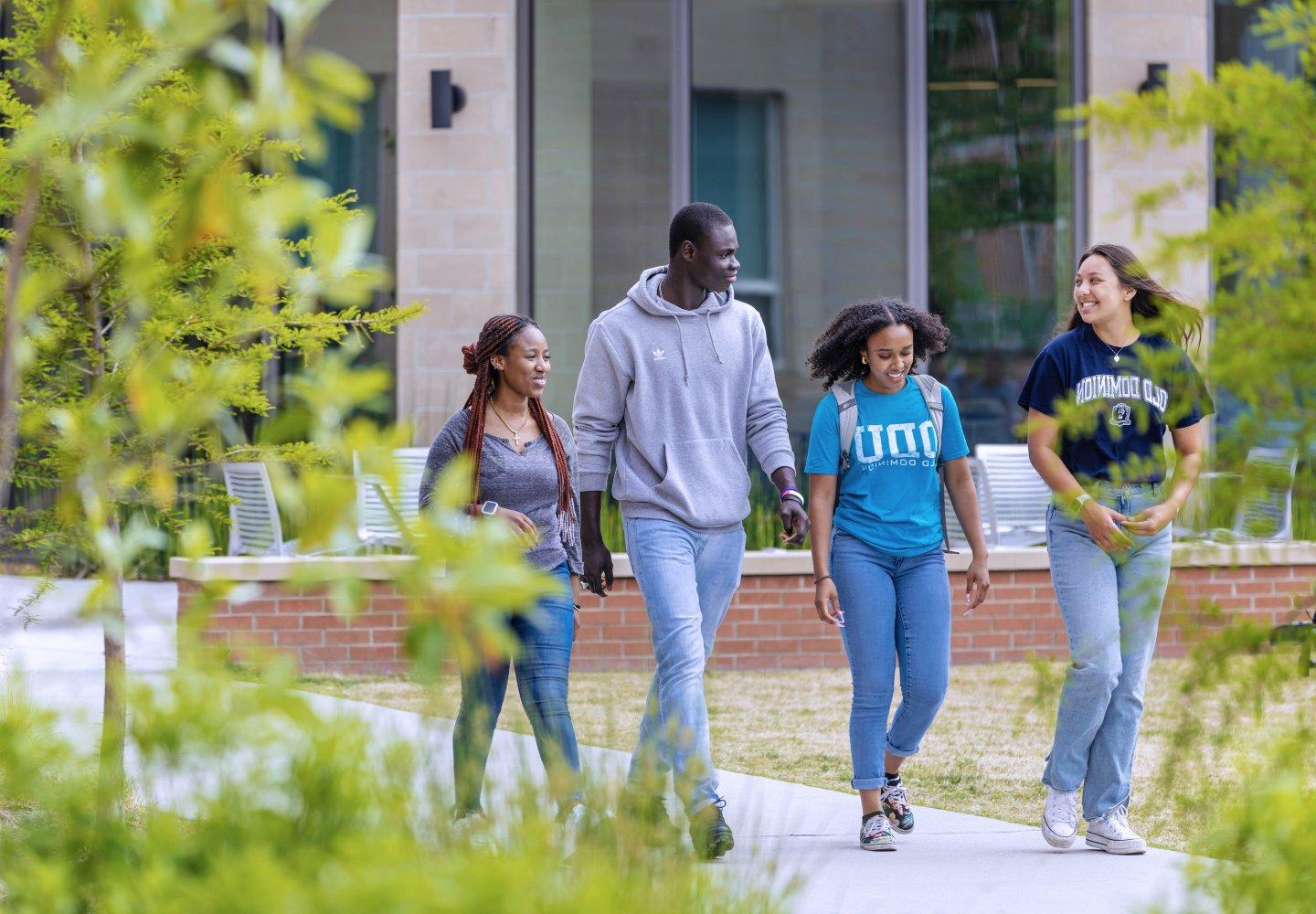 A group of students walking in front of Owens House residence hall